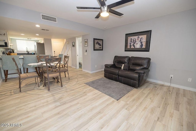 living room with ceiling fan and light hardwood / wood-style floors