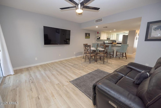 living room featuring ceiling fan and light wood-type flooring