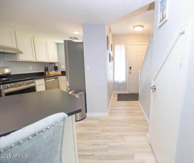 kitchen with white cabinetry, appliances with stainless steel finishes, and light wood-type flooring