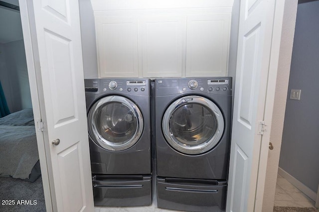 laundry area featuring cabinets and washing machine and clothes dryer