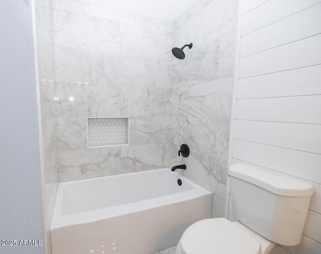 bathroom with toilet and tiled shower / bath