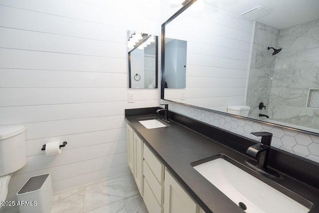 bathroom with vanity, wood walls, and a tile shower