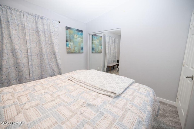 bedroom featuring a closet, vaulted ceiling, and carpet