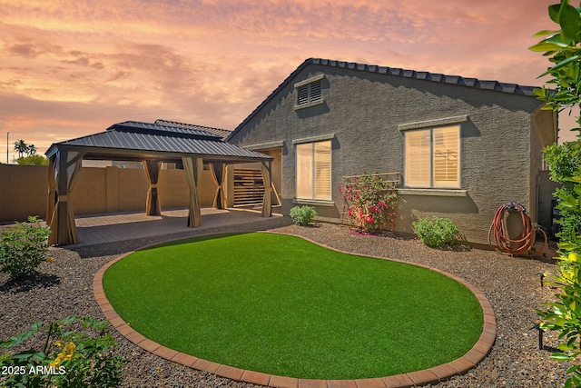 back of property featuring a patio, a gazebo, stucco siding, and fence