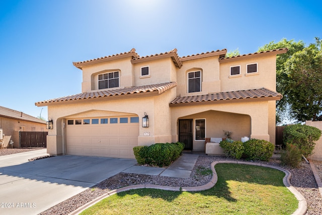 mediterranean / spanish house with a front lawn and a garage