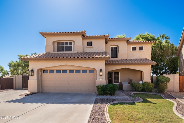 mediterranean / spanish house with a garage and a front lawn