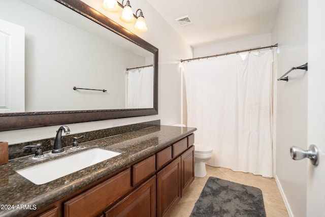 bathroom with a shower with curtain, vanity, toilet, and tile patterned floors