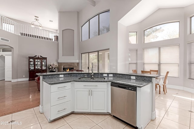 kitchen with open floor plan, light tile patterned floors, a sink, visible vents, and dishwasher