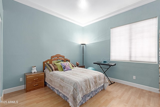 bedroom featuring baseboards, ornamental molding, and wood finished floors