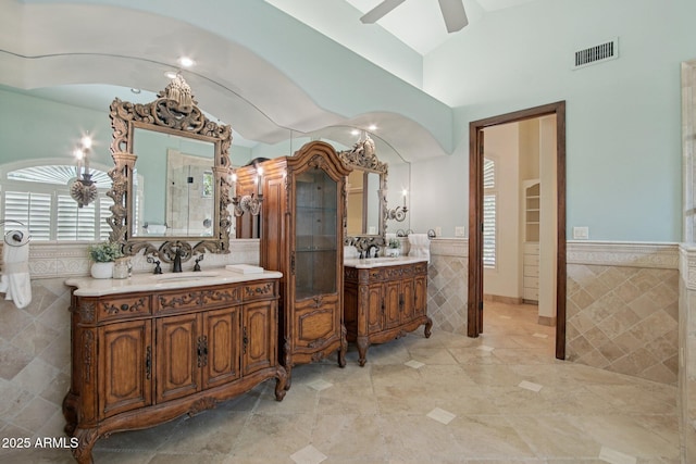 1330 N 40th St Unit 1, Mesa, AZ 85205 - full bathroom featuring tile walls, vaulted ceiling, two vanities, a wainscoted wall, and ceiling fan