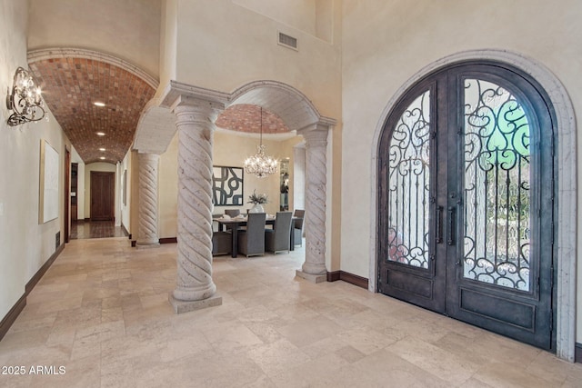 1330 N 40th St Unit 1, Mesa, AZ 85205 - foyer entrance featuring decorative columns, french doors, stone tile floors, a chandelier, and arched walkways