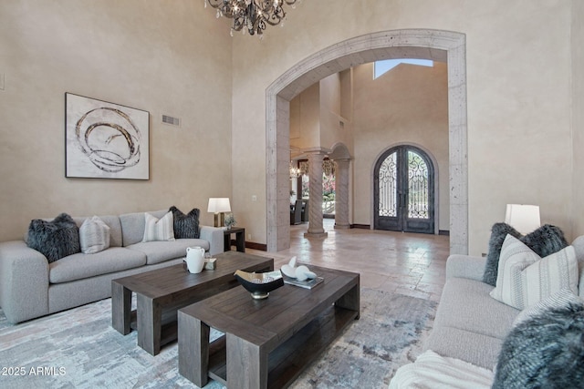 1330 N 40th St Unit 1, Mesa, AZ 85205 - living area featuring arched walkways, a high ceiling, stone tile flooring, a chandelier, and ornate columns