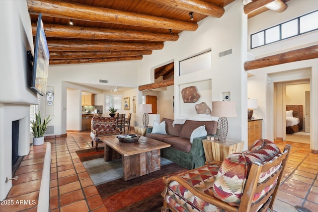 living area with wood ceiling, light tile patterned flooring, beamed ceiling, and visible vents