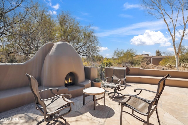 view of patio / terrace with a lit fireplace