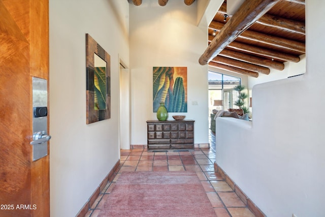 corridor with wood ceiling, baseboards, beam ceiling, and tile patterned floors