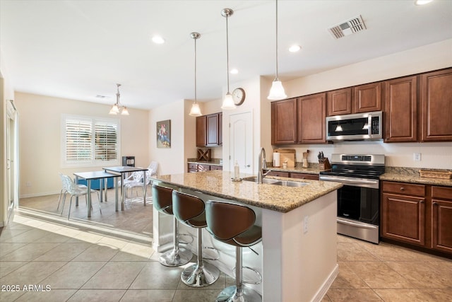 4032 S Santa Rita Pl, Chandler, AZ 85249 - kitchen featuring appliances with stainless steel finishes, a sink, light tile patterned floors, light stone countertops, and pendant lighting