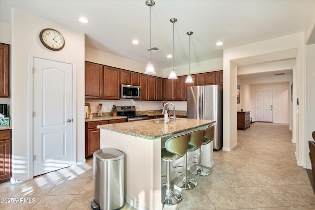 4032 S Santa Rita Pl, Chandler, AZ 85249 - kitchen with appliances with stainless steel finishes, a sink, light tile patterned flooring, light stone countertops, and a center island with sink