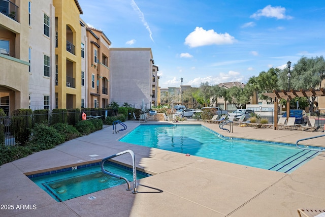 pool featuring a patio, a hot tub, and fence