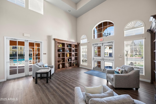 living area featuring dark wood finished floors, visible vents, french doors, and baseboards