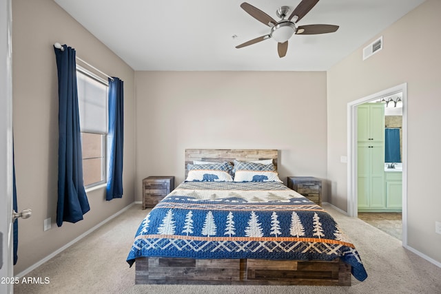 carpeted bedroom with ensuite bath, baseboards, visible vents, and ceiling fan