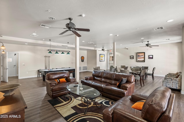 living area featuring wood finished floors, baseboards, and visible vents