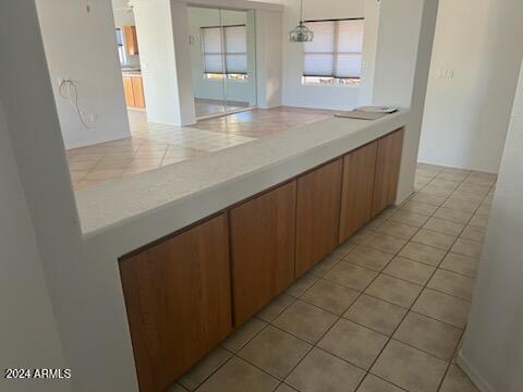 kitchen with brown cabinets, light tile patterned floors, and light countertops