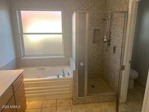 bathroom with tile patterned flooring, a garden tub, toilet, vanity, and a stall shower