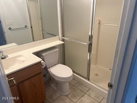 bathroom with toilet, tile patterned flooring, vanity, and a shower stall