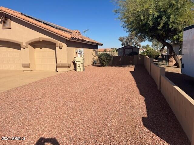 view of yard with concrete driveway, fence, and an attached garage