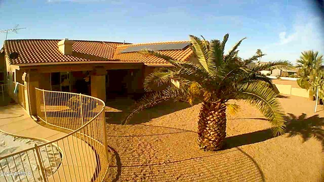 back of property featuring a tiled roof