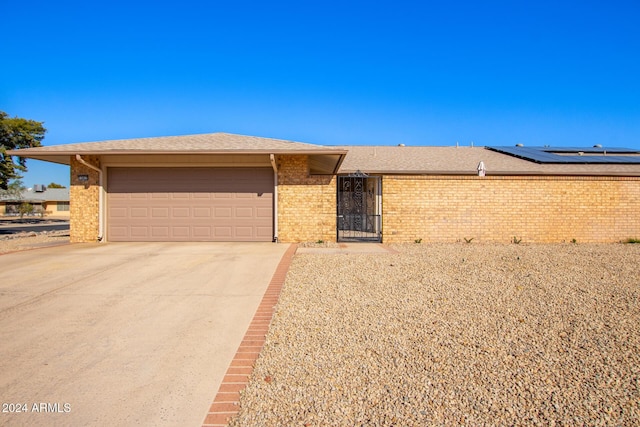 view of front of property with solar panels and a garage