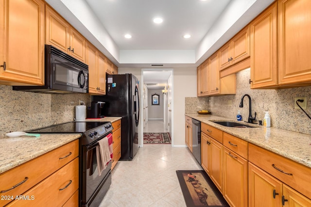 kitchen with light stone countertops, tasteful backsplash, black appliances, sink, and light tile patterned flooring