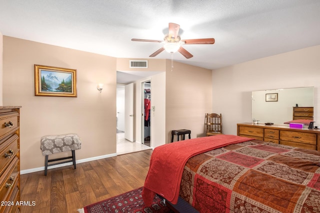 bedroom featuring a textured ceiling, ceiling fan, a spacious closet, hardwood / wood-style floors, and a closet