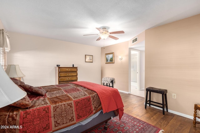 bedroom featuring a textured ceiling, dark hardwood / wood-style floors, and ceiling fan