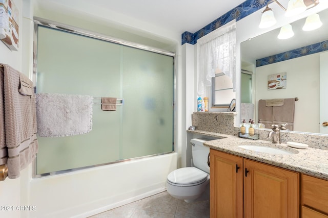 full bathroom with tile patterned flooring, vanity, bath / shower combo with glass door, and toilet