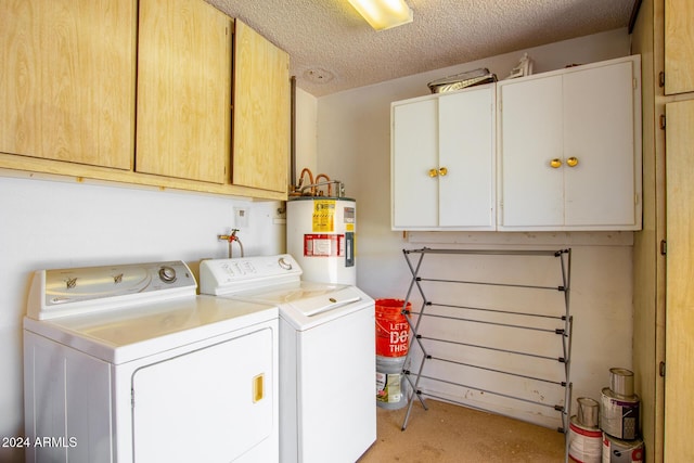 laundry area with cabinets, washing machine and clothes dryer, a textured ceiling, and water heater