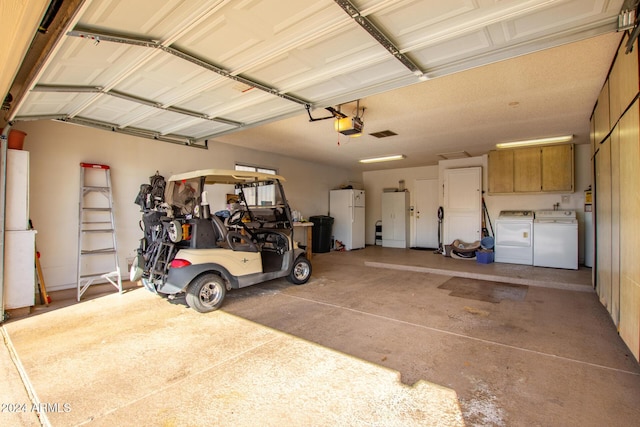 garage with washer and clothes dryer, a garage door opener, and white refrigerator