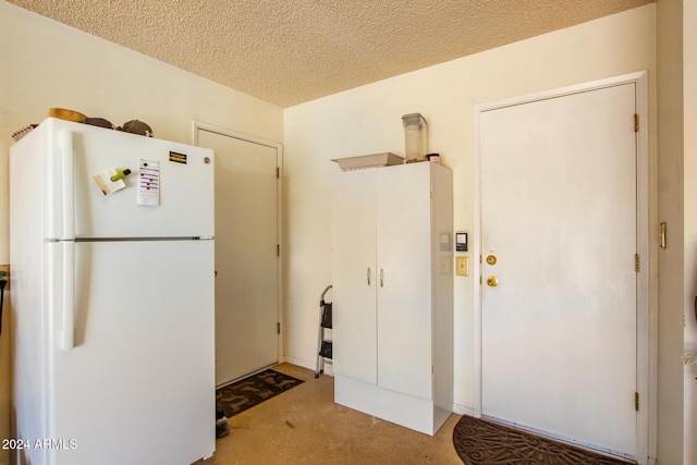 kitchen featuring white refrigerator and a textured ceiling