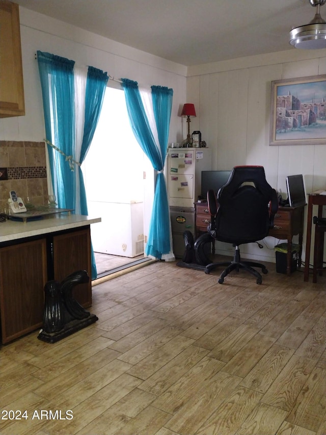 home office with light hardwood / wood-style floors