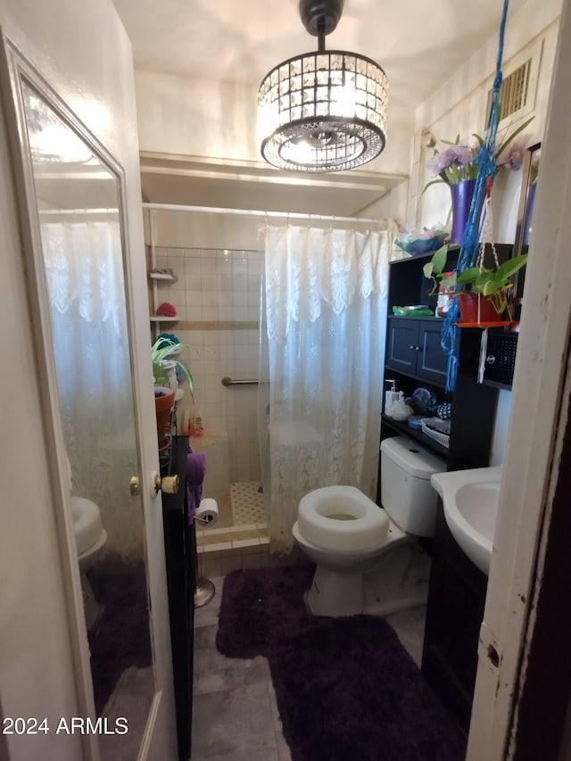 bathroom featuring tile patterned floors, vanity, toilet, and curtained shower