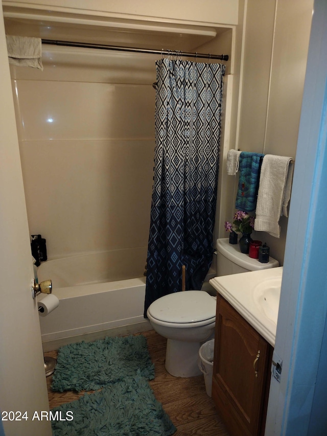 full bathroom with shower / bath combo with shower curtain, vanity, wood-type flooring, and toilet