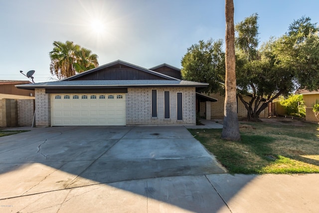 ranch-style house with driveway, an attached garage, board and batten siding, and brick siding