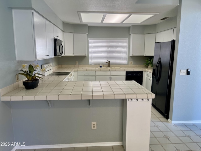 kitchen with sink, black appliances, kitchen peninsula, and white cabinets