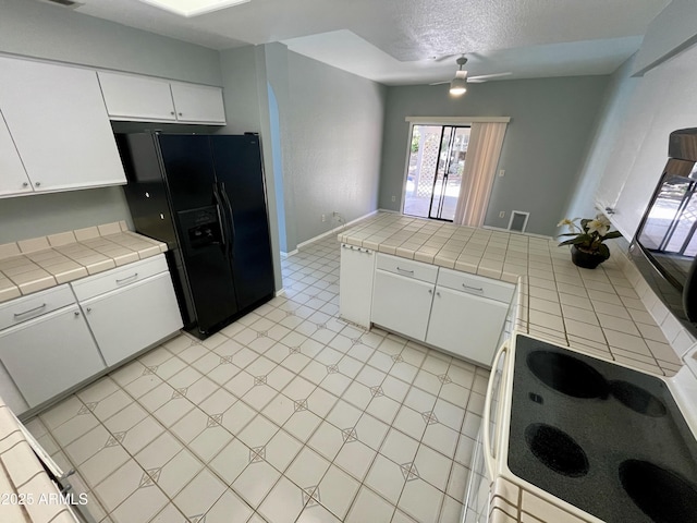 kitchen featuring white cabinetry and tile counters