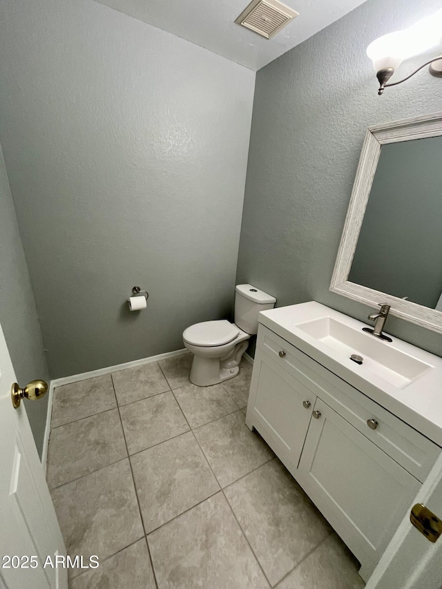 bathroom with tile patterned flooring, vanity, and toilet