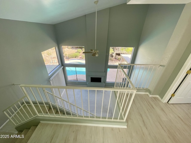 stairs featuring hardwood / wood-style flooring and ceiling fan