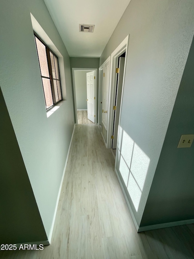 corridor with light wood-type flooring