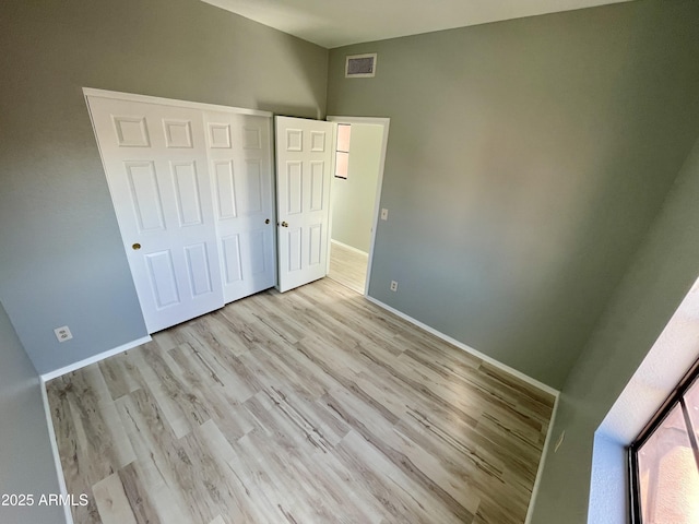 unfurnished bedroom featuring a closet and light hardwood / wood-style flooring