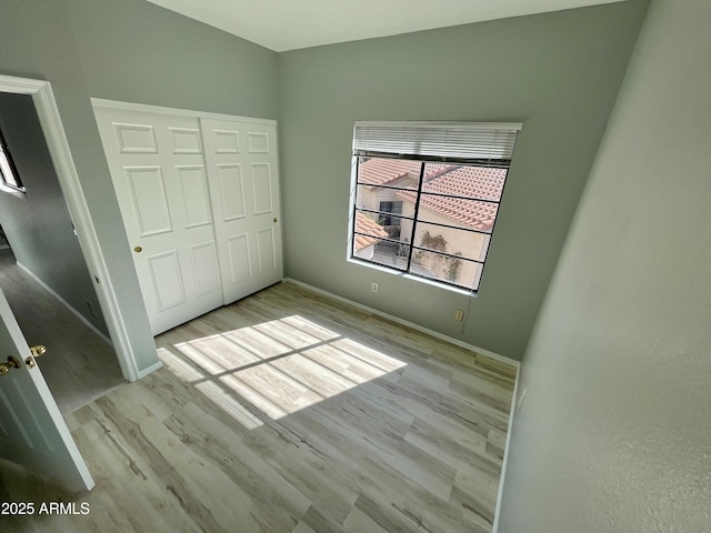 unfurnished bedroom with a closet and light wood-type flooring