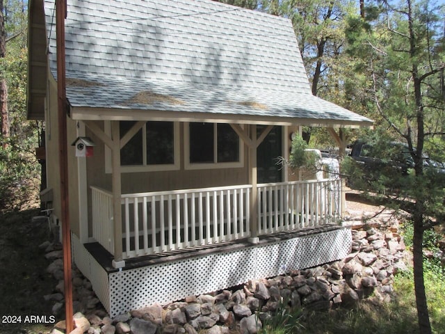 exterior space featuring a shingled roof